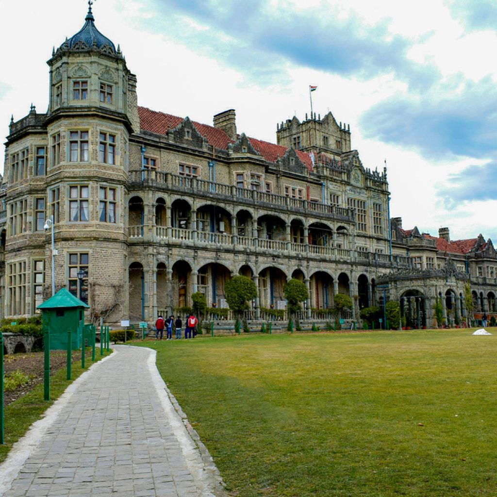 Indian Institute of Advanced Study, Shimla, formerly known as the Viceregal Lodge, a grand stone building with intricate architectural details, surrounded by a green lawn and a walkway leading to the entrance.
